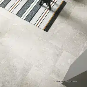 Pale stone-look floor tiles beside a striped rug